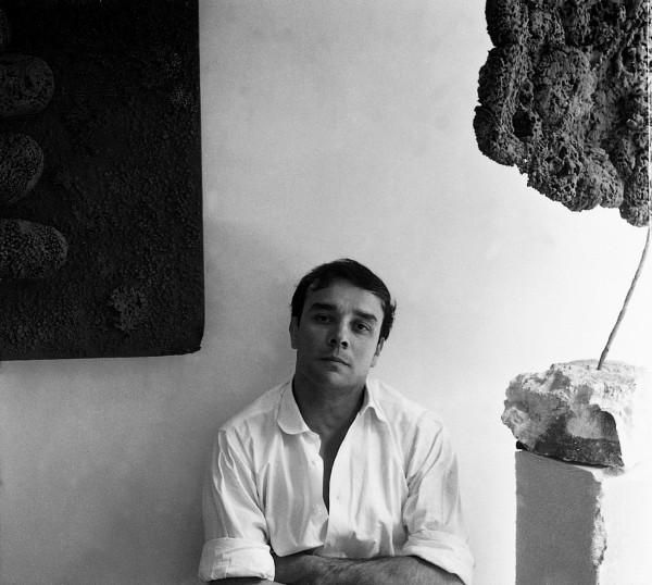 Portrait of Yves Klein in front of the Sponge Relief (RE 19) and the Sponge Sculpture (SE 260)