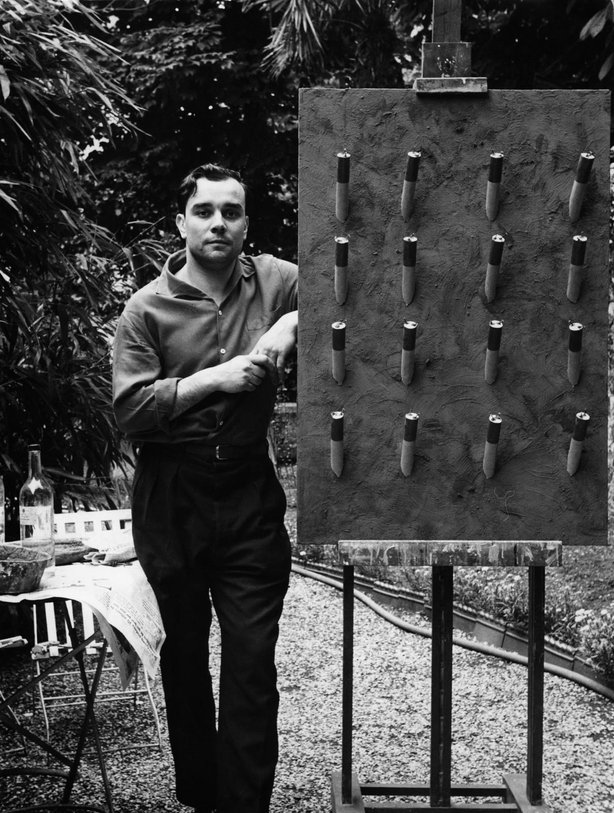 Yves Klein in front of his artwork "Tableau de feu bleu d’une minute", (M 41),in the garden of the Colette Allendy Gallery, Paris, 1957
