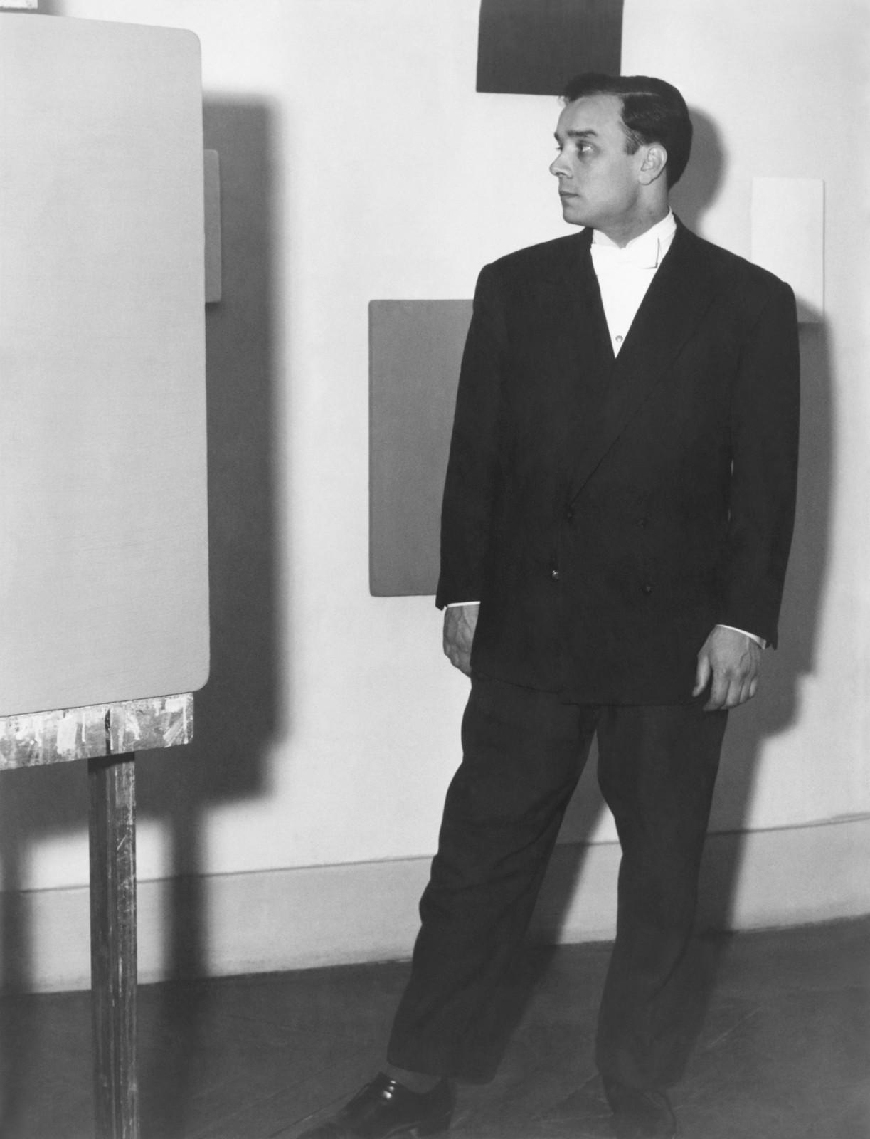 Portrait of Yves Klein in front of his Monochromes